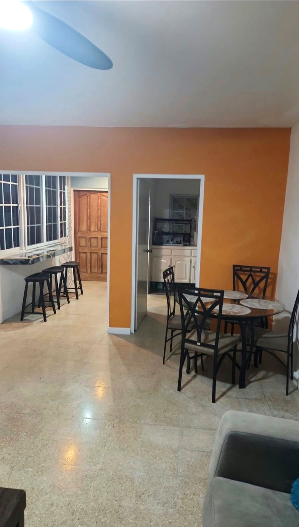 Actual condo dining area with orange accent wall and sunroom bar