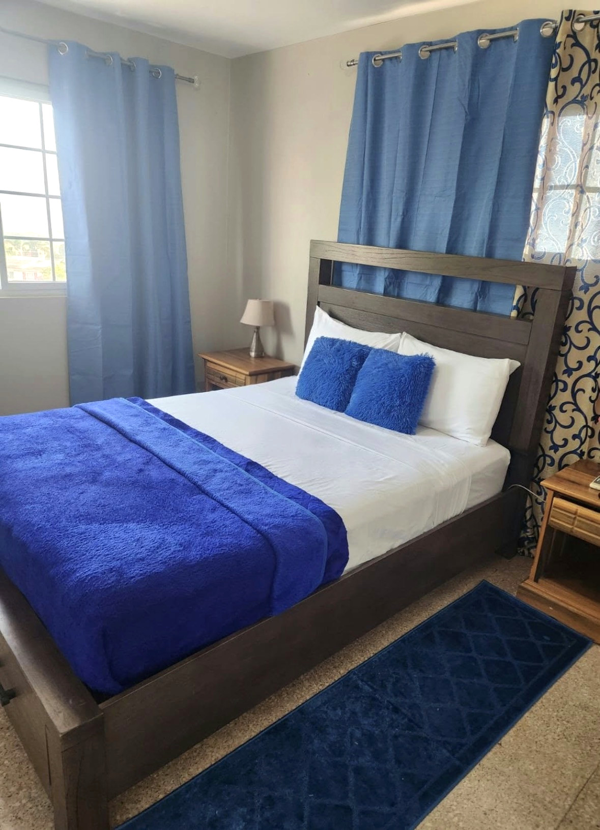 Condo bedroom with blue curtains and blue bedding